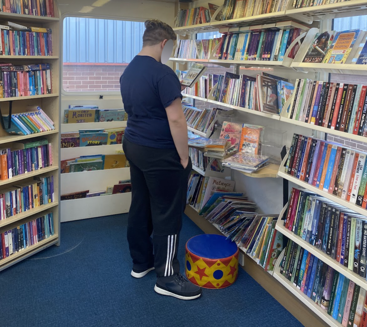 A student choosing a book on board the library bus