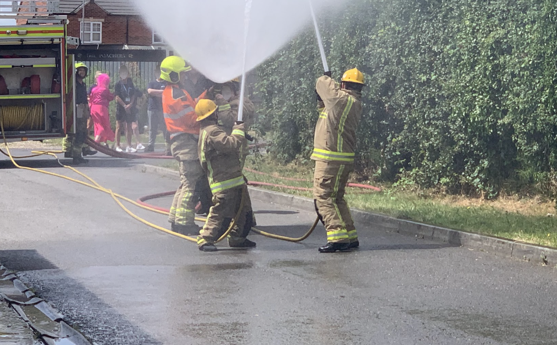 Students directing a fire hose during a training exercise with the fire service