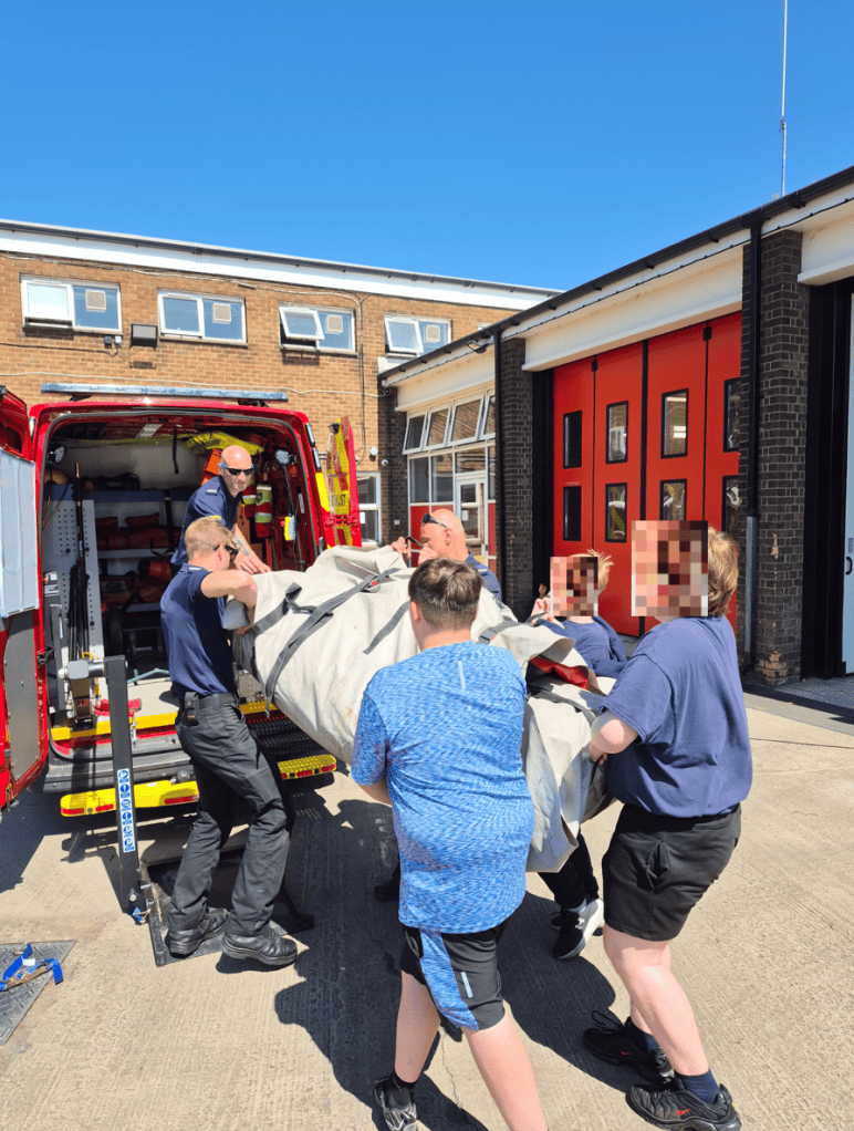 Students practising manual lifting as a team with Humberside Fire & Rescue officers